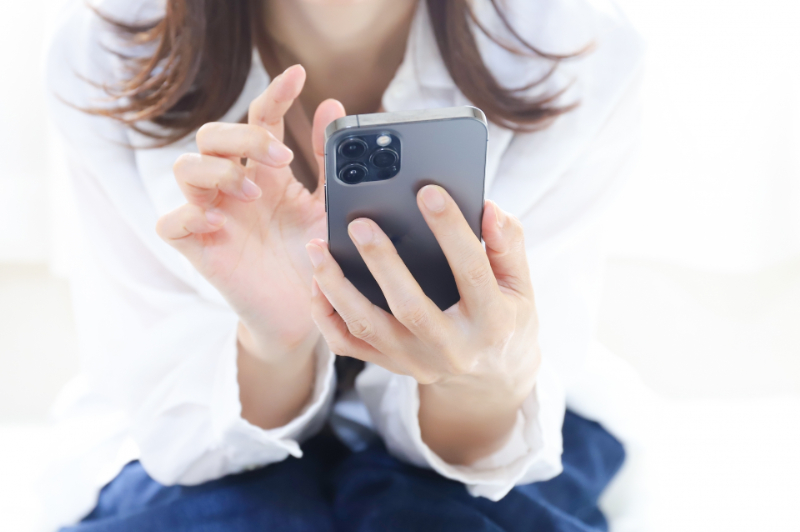 スマホでホームページを閲覧中の女性イメージ